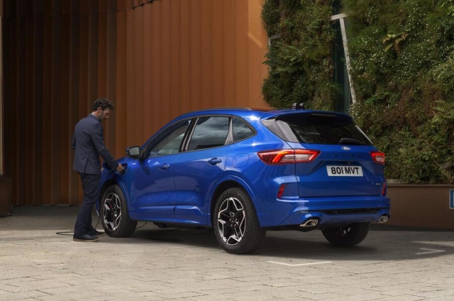 man_plugs_in_a_blue_ford_kuga_plug-in_hybrid