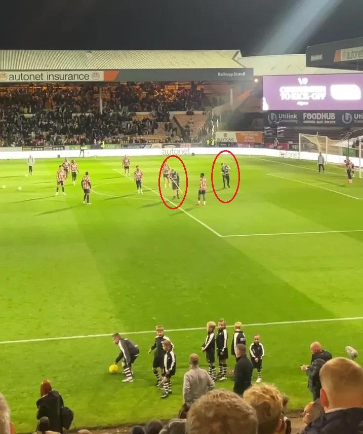 Arsenal bị chơi xấu ngay cả từ... nhân viên chăm sóc cỏ! 5 2 nhân viên sân của Port Vale tiến vào khu vực tập bóng của Arsenal. (Ảnh: The Sun)