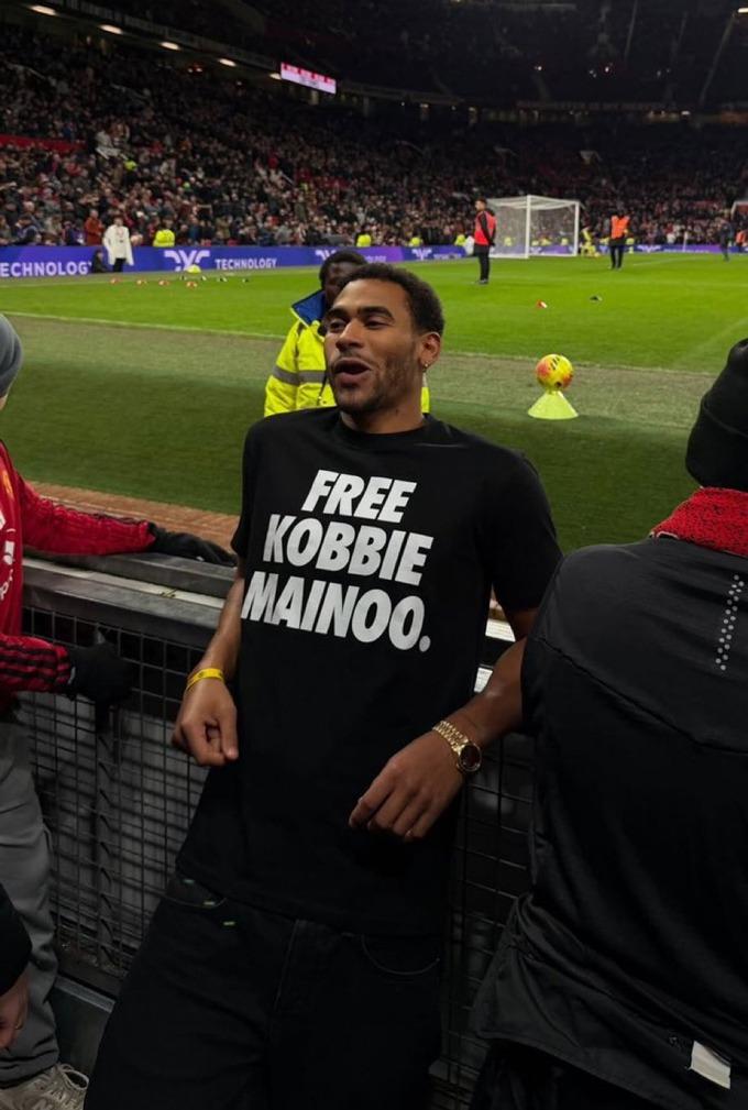 Anh trai Kobbie Mainoo và thông điệp 'giải cứu Mainoo' trên khán đài (Ảnh: AP).