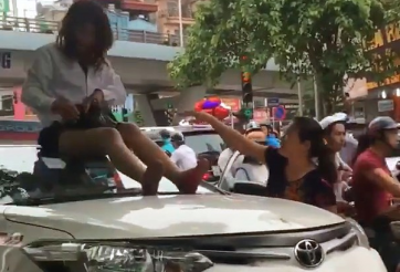 Nữ tài xế taxi mặc váy ngồi nóc ô tô chống đối CSGT