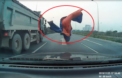 Xe tải đánh rơi bạt trùm kín đầu xe con, tài xế thót tim phanh gấp