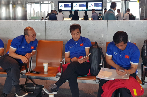 HLV Park Hang-seo tranh thủ trao đổi công việc với các trợ lý trong thời gian chờ nối chuyến tại Doha.