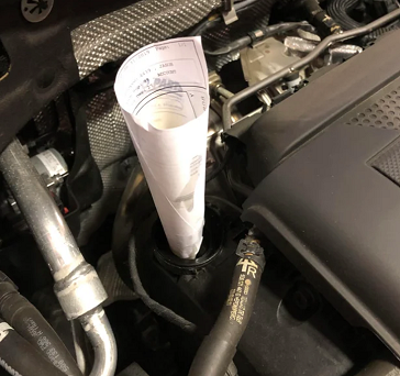 Sử dụng giấy nhúm thay thế phễu nhựa rót dầu ở trên xe